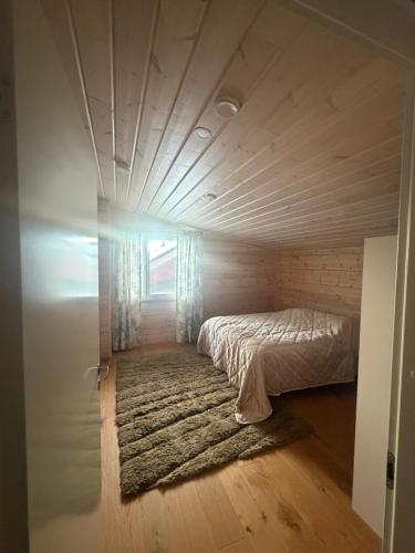 un letto in una piccola stanza con un tappeto di Villa Siltasaari a Sotkamo