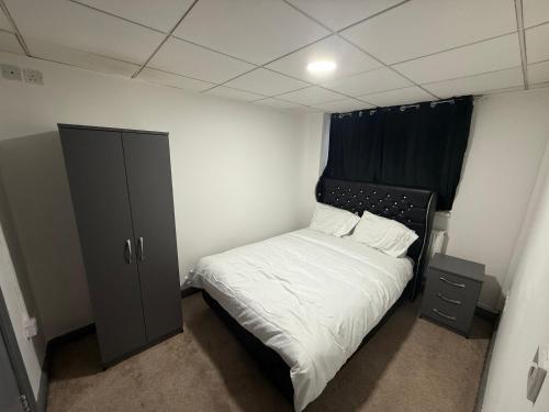 a small bedroom with a bed and a cabinet at Prime Hotel in Birmingham