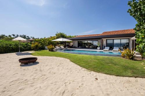 a house on the beach with a swimming pool at Beachfront Villa with Butler and Private Pool in Punta Mita