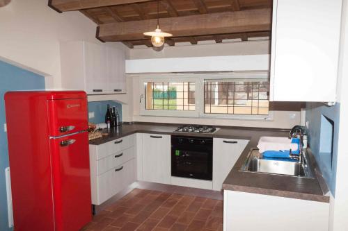 una cucina con frigorifero rosso e lavandino di Villa Cortellini a San Clemente