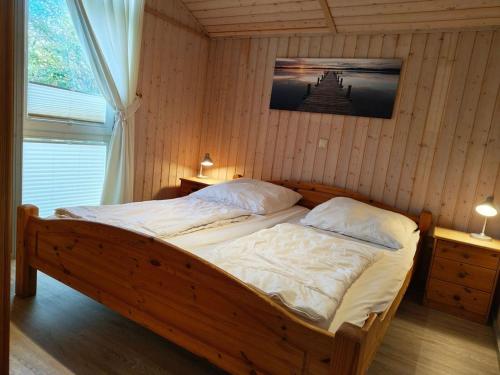 een slaapkamer met een houten bed in een kamer bij Ferienhaus im skandinavischen Stil in Rechlin
