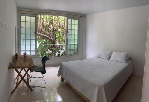 una camera da letto con un letto, una sedia e una finestra di Paulas place a Garzón