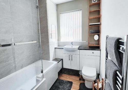 a bathroom with a toilet and a sink and a bath tub at Stylish & Modern 2BR Flat nr Nottingham City Centre in Nottingham