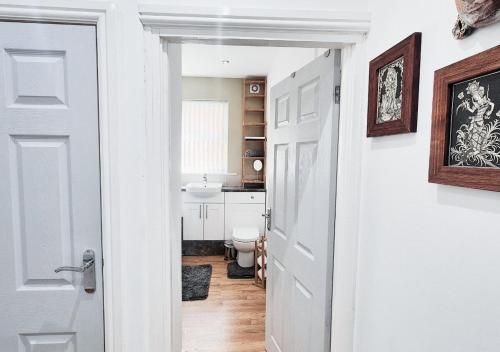 a white bathroom with a toilet and a sink at Stylish & Modern 2BR Flat nr Nottingham City Centre in Nottingham