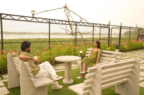a man and a woman sitting on a bench at The Lawrences Aqua Stay in Cochin