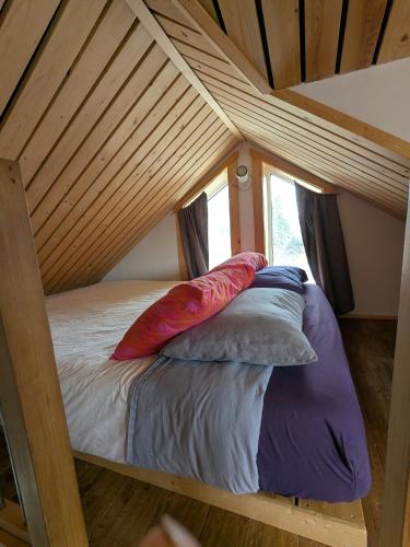 a bed in a room with a wooden ceiling at Yukon Sweet Spot Bed and Bakery in Whitehorse