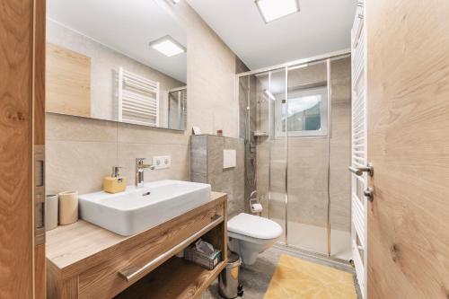 een badkamer met wastafel, douche en toilet bij MonteVita Pitztal Panorama Apartments 