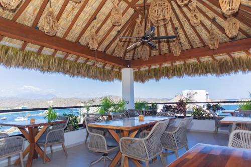 GaritaにあるCasa Vanoraのテーブルと椅子があり、海の景色が見えるパティオ