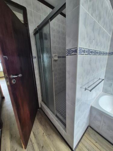 a shower with a glass door in a bathroom at Jakaranda Holiday Flat in Uvongo Beach