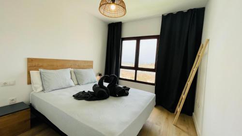 a bedroom with a bed with a pair of shoes on it at Ola Cotillo Beach El Cotillo in El Cotillo