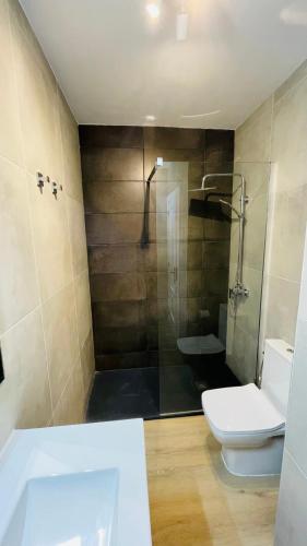a bathroom with a shower and a toilet and a sink at Ola Cotillo Beach El Cotillo in El Cotillo
