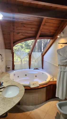 a large bathroom with a tub and a sink at Casa Del Bosque Aparts in Villa La Angostura