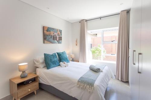 York Escape - Townhouse 26 في جورج: غرفة نوم مع سرير ووسائد زرقاء ونافذة