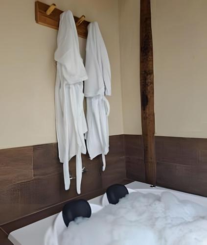 a bedroom with white robes hanging on a wall at Chalé com bela vista para as montanhas in Resende