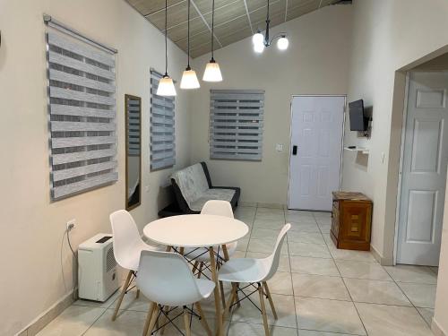 a dining room with a table and white chairs at Casa Colibrí, entera, Volcán in Volcán