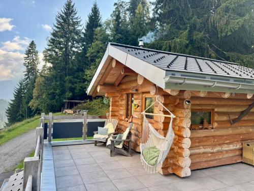 La ComballazThe Forest House的露台上的小木屋，配有吊床