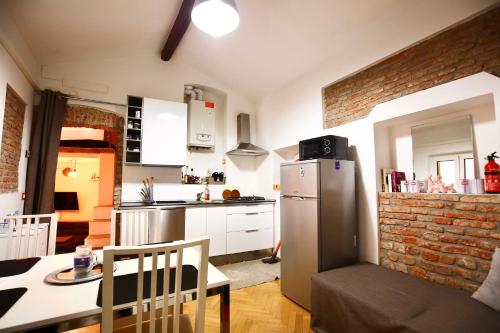 una cucina con frigorifero e tavolo con sedia di Penthouse in central Milan a Milano