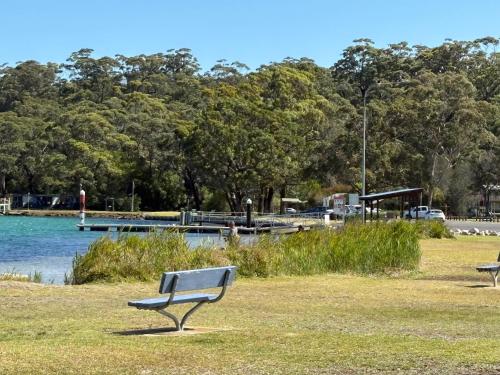 two benches in a park near a body of water at Waterview Motel Sussex Inlet in Sussex inlet