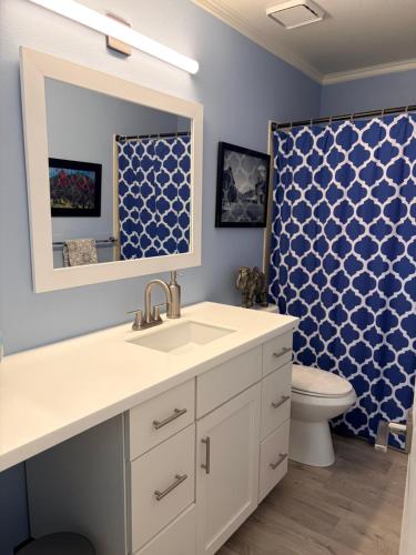 Un baño con lavabo, inodoro y espejo. en Boulder Best, en Boulder