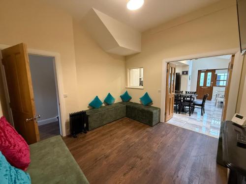 a living room with a green couch with blue pillows at The Townlets Townhouse - 5BR - sleeps 13 in Belfast