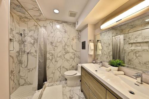 a bathroom with a shower and a toilet and a sink at Ice District 2 Kings Private Parking Patio in Edmonton