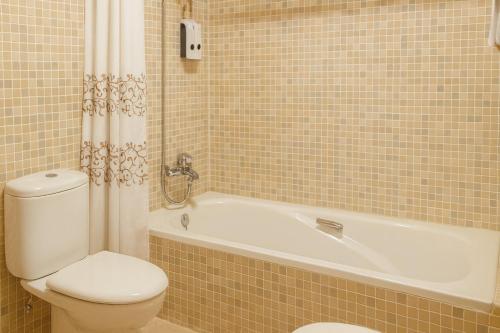 La salle de bains est pourvue de toilettes, d'une baignoire et de toilettes. dans l'établissement Vall Fosca - Apartamento con espectaculares vistas y jardín privado, à Torre de Capdella