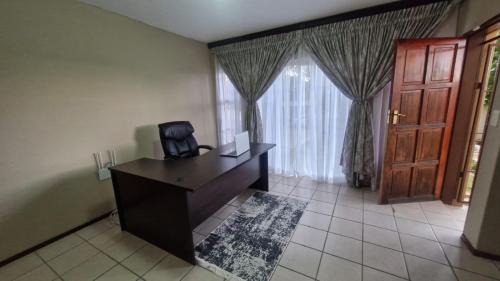 an office with a desk with a computer and a window at Nkwe Guesthouse in Roodepoort