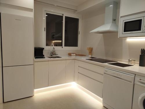 a kitchen with white cabinets and a light on the floor at Nunes Luxury in Ronda