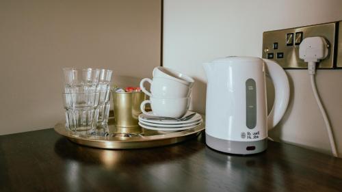 a counter with a coffee maker and glasses on it at Adams Townhouse in Dingle