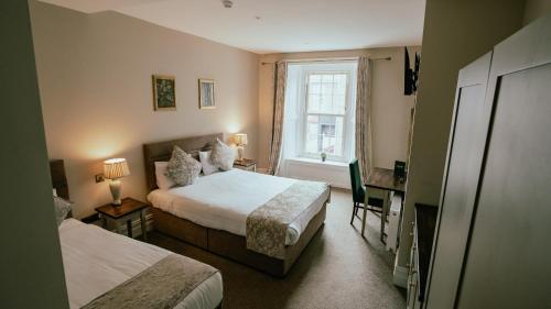 ディングルにあるAdams Townhouseのベッドが2つと窓があるホテルの部屋