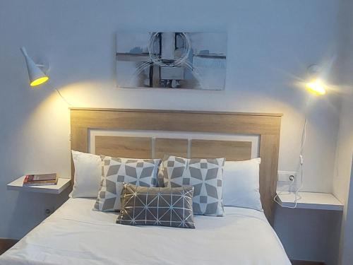Un dormitorio con una cama blanca con almohadas. en Apartamento Vive Teruel, en Teruel