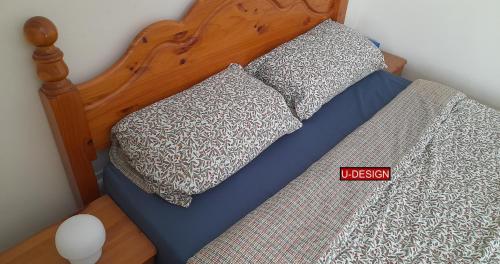 a bed with two pillows on top of it with a red sign at Parkside Studio in Luton