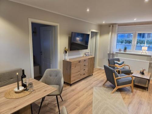 Cozy Luhe Cottage في بيسبينغين: غرفة معيشة مع تلفزيون وطاولة وكراسي