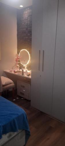 een slaapkamer met een bed en een wastafel met een spiegel bij Dois Quartos Completo in Vila Velha