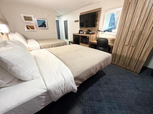 a hotel room with two beds and a desk at Quality Inn Ponca City in Ponca City