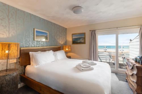 a bedroom with a bed with a view of the ocean at Rwts-rooms and resto in Broad Haven
