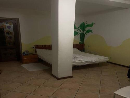 a bedroom with a bed with a palm tree on the wall at SnowPeak Residence in Dresano