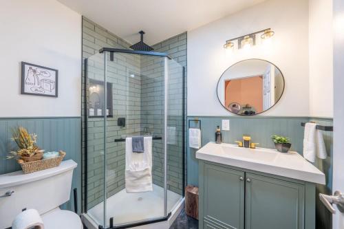 a bathroom with a glass shower and a sink at 7BR 5BTH House Steps to Bars Dining NYC Access with GameRm Backyard with BBQ and Parking in Jersey City