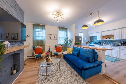 a living room with a blue couch and a fireplace at 7BR 5BTH House Steps to Bars Dining NYC Access with GameRm Backyard with BBQ and Parking in Jersey City