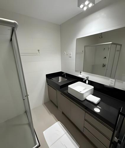 a bathroom with a sink and a mirror at Studio Compacto com Design Clean no Vertigo in Campo Grande