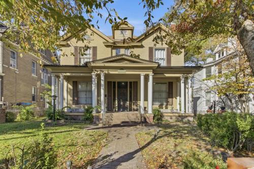 a large yellow house with columns at Historic Midtown Apartment in Memphis
