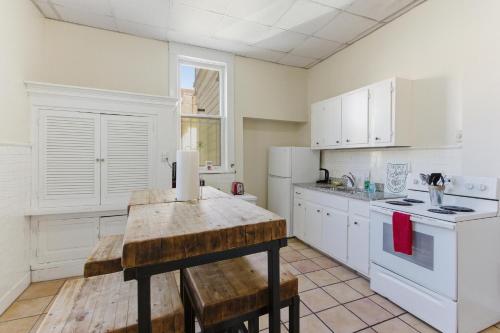 a kitchen with white cabinets and a wooden table at Historic Midtown Apartment in Memphis