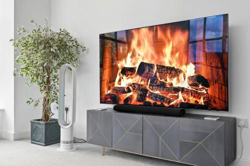 a fireplace in a living room with a tv at Castle View by Ginger & Gold Luxury Norwich Apt in Norwich