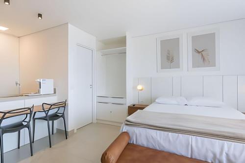 a bedroom with a bed and a table and chairs at Stay Pure | Design Clean e Atmosfera Tranquila in Campo Grande