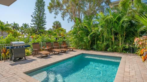 a swimming pool in a yard with chairs and a table at Casa Coquina - 1038U in Siesta Key