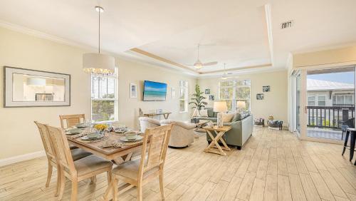 a dining room and living room with a table and chairs at Casa Coquina - 1038U in Siesta Key