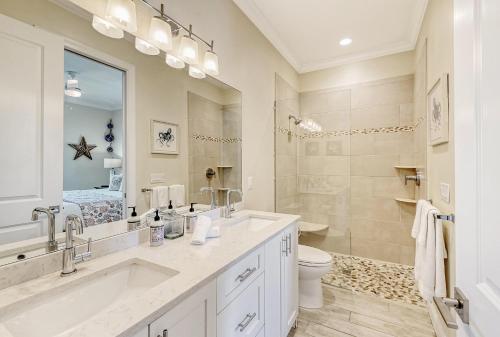a bathroom with a sink and a toilet and a mirror at Casa Coquina - 1038U in Siesta Key