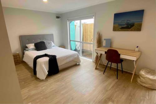 a bedroom with a bed and a desk and a deskablish at The Sugar shack in Tauranga