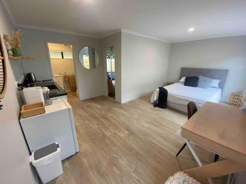 a bedroom with a bed and a desk and a table at The Sugar shack in Tauranga