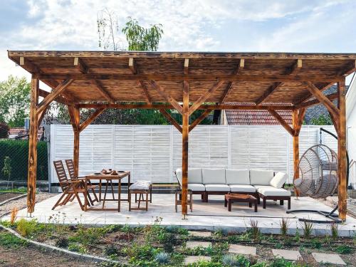 a wooden pavilion with chairs and a table at Makravölgyi Házikó in Csajág